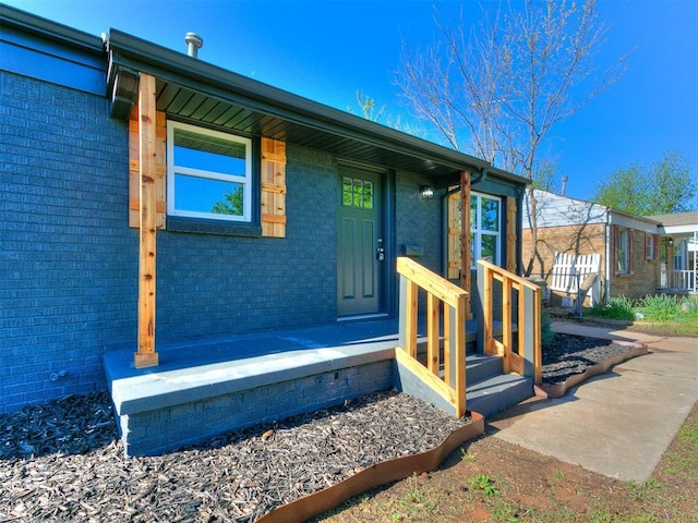 doorway to property featuring brick siding