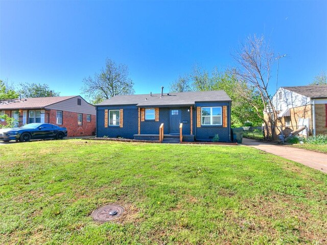 view of front of home featuring brick siding, a front yard, and fence
