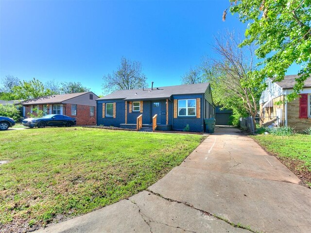 single story home featuring fence, a front lawn, brick siding, and concrete driveway