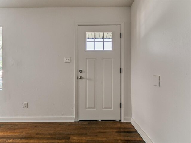 doorway with baseboards and dark wood-style floors