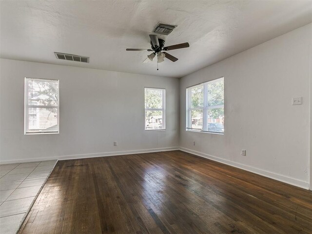 empty room with ceiling fan, baseboards, hardwood / wood-style floors, and visible vents