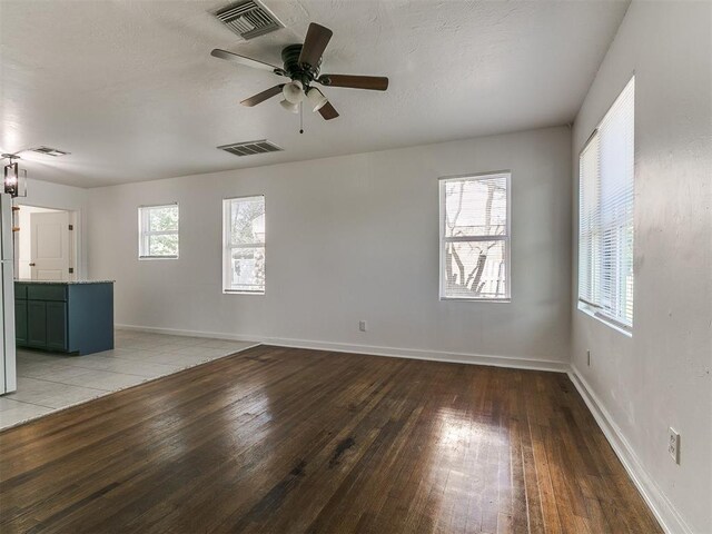 unfurnished living room featuring light wood-style floors, visible vents, and baseboards