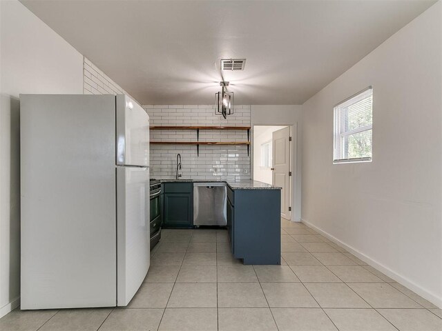 kitchen featuring stainless steel appliances, open shelves, visible vents, light tile patterned floors, and a sink