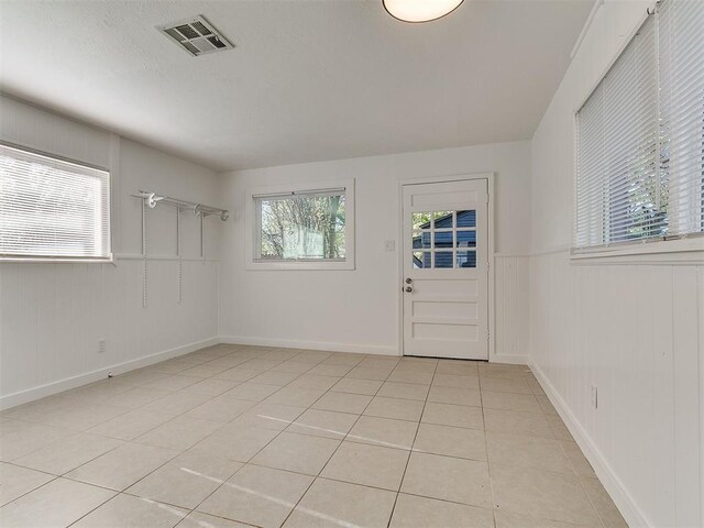 foyer featuring light tile patterned flooring, visible vents, and baseboards