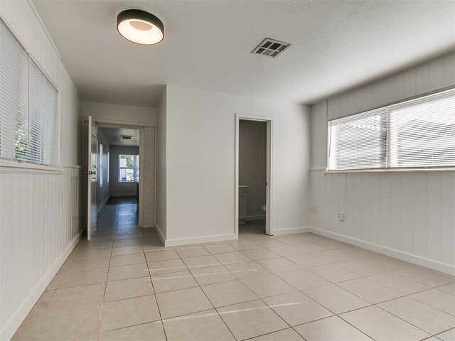 unfurnished bedroom featuring baseboards, visible vents, and light tile patterned flooring