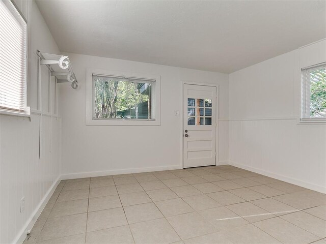 empty room featuring light tile patterned flooring and baseboards