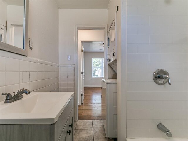 full bathroom featuring tile walls, vanity, tile patterned flooring, and walk in shower