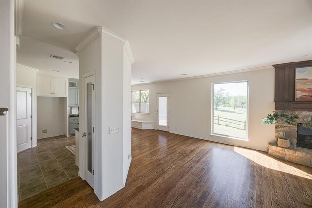 4940 Sonny Blues Pl, Edmond, OK 73034 - unfurnished living room with baseboards, crown molding, dark wood-type flooring, and visible vents