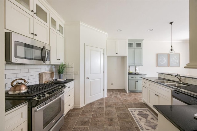 4940 Sonny Blues Pl, Edmond, OK 73034 - kitchen featuring decorative backsplash, pendant lighting, a sink, and appliances with stainless steel finishes