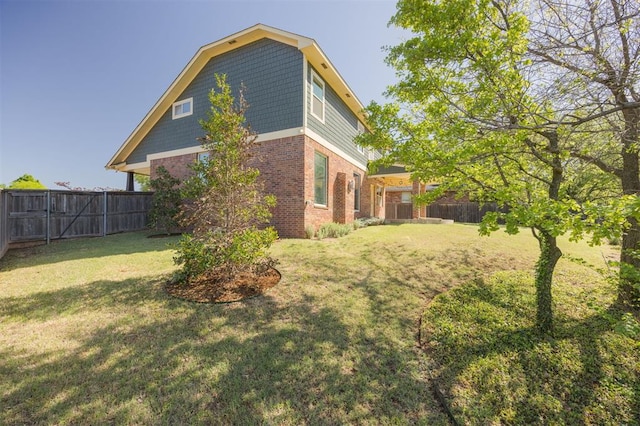 4940 Sonny Blues Pl, Edmond, OK 73034 - view of side of home with a lawn, a fenced backyard, and brick siding