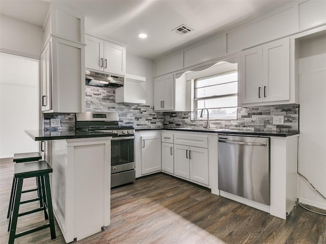 603 N Madison Ave, Blanchard, OK 73010 - kitchen featuring tasteful backsplash, dark countertops, visible vents, under cabinet range hood, and appliances with stainless steel finishes