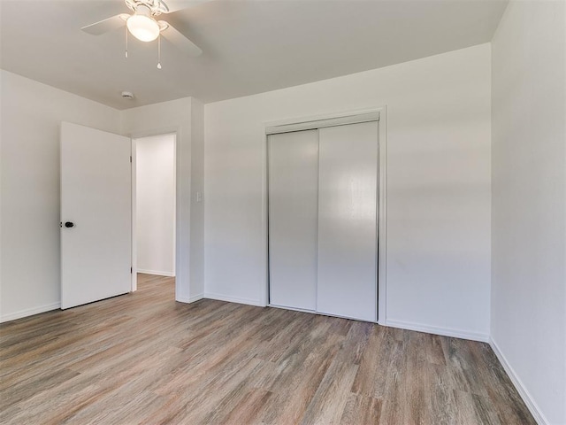 603 N Madison Ave, Blanchard, OK 73010 - unfurnished bedroom with baseboards, wood finished floors, a closet, and ceiling fan