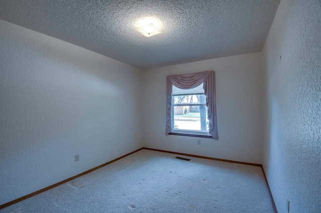 1117 Blue Ridge Dr, Edmond, OK 73003 - spare room featuring a textured wall, a textured ceiling, light colored carpet, and baseboards