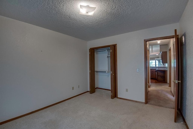 1117 Blue Ridge Dr, Edmond, OK 73003 - unfurnished bedroom featuring light colored carpet, a textured ceiling, a closet, and baseboards