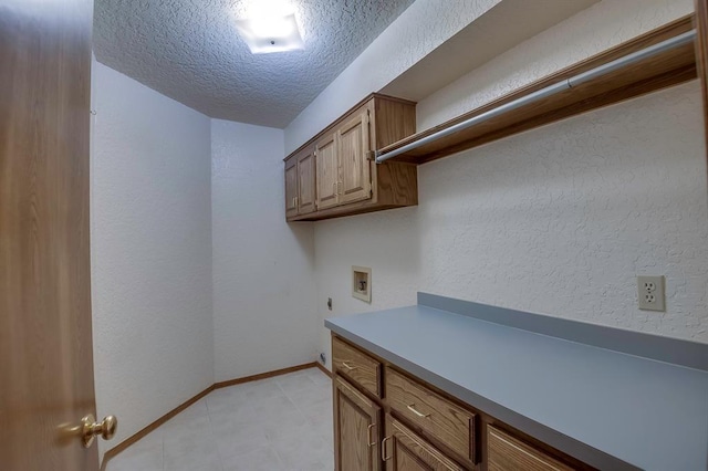 1117 Blue Ridge Dr, Edmond, OK 73003 - laundry area featuring hookup for an electric dryer, a textured ceiling, washer hookup, cabinet space, and baseboards