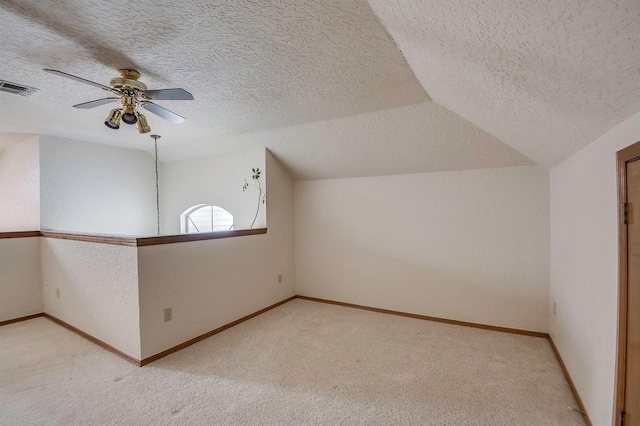 1117 Blue Ridge Dr, Edmond, OK 73003 - bonus room featuring carpet flooring, a textured ceiling, a ceiling fan, vaulted ceiling, and baseboards