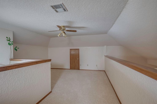 1117 Blue Ridge Dr, Edmond, OK 73003 - additional living space featuring vaulted ceiling, a textured ceiling, ceiling fan, and light colored carpet