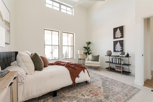 carpeted bedroom featuring baseboards, a high ceiling, and ornamental molding