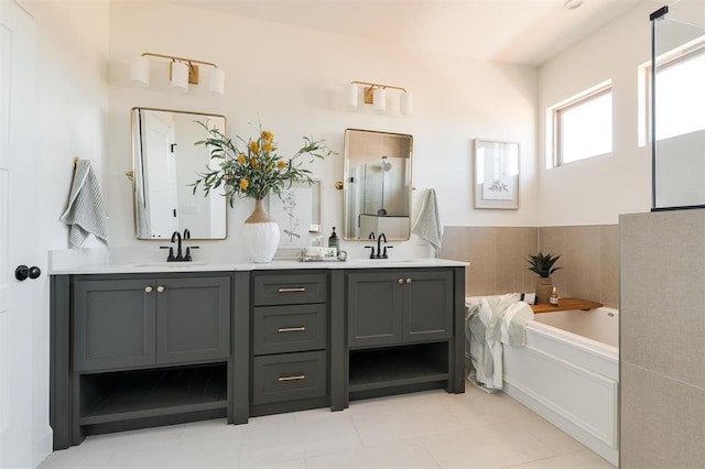 bathroom with double vanity, a garden tub, tile patterned floors, and a sink