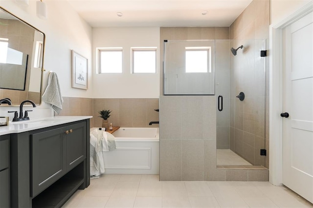 full bath featuring a garden tub, vanity, tile patterned flooring, and a stall shower