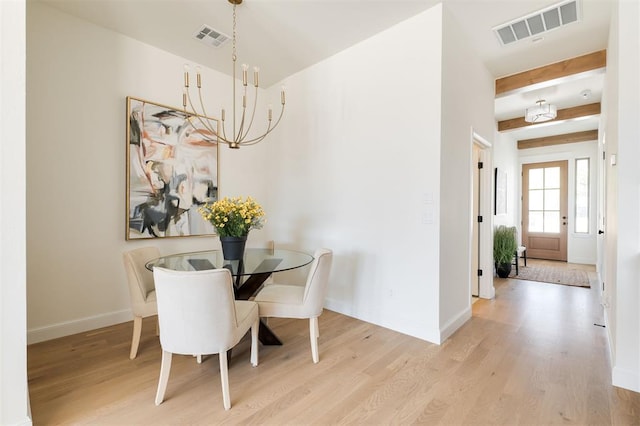 dining space with baseboards, a chandelier, visible vents, and light wood-type flooring