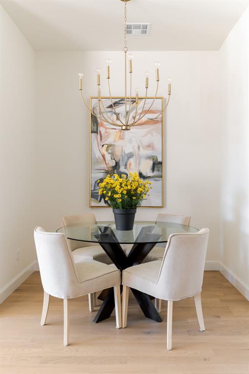dining room featuring baseboards, an inviting chandelier, and light wood-style floors