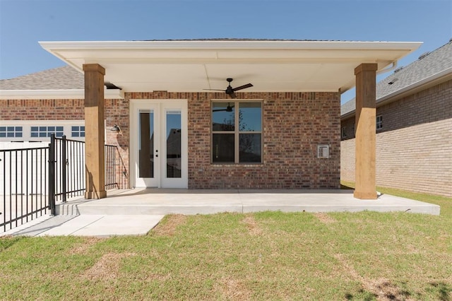 rear view of property with ceiling fan, brick siding, and a patio