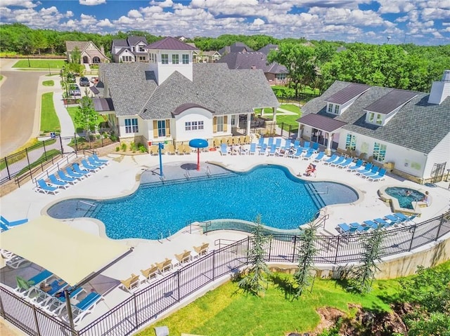 pool with a patio and fence