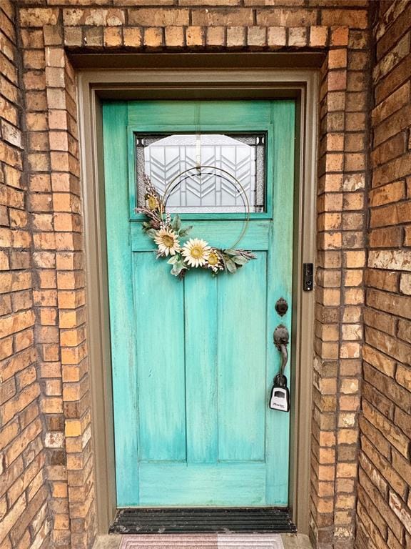 doorway to property with brick siding