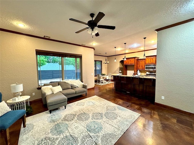 living room featuring ornamental molding, a textured wall, and baseboards