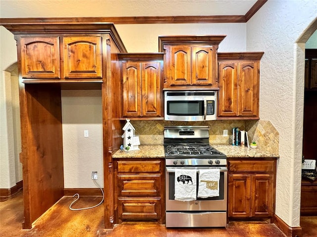 kitchen featuring light stone countertops, stainless steel appliances, backsplash, a textured wall, and crown molding