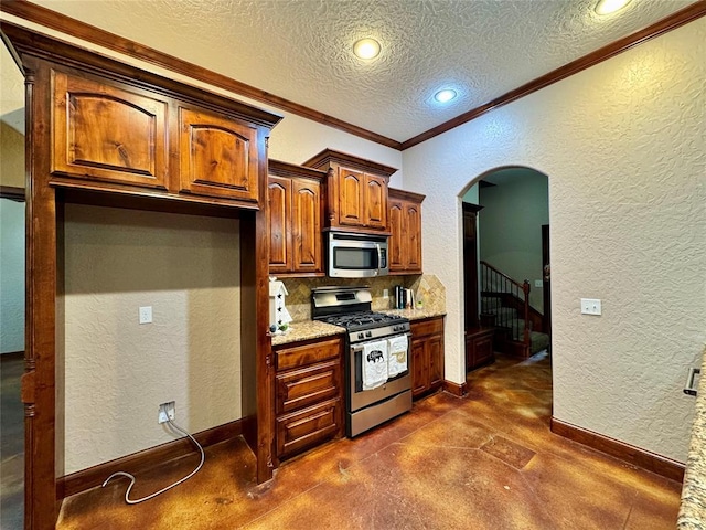 kitchen with stainless steel appliances, a textured ceiling, a textured wall, and finished concrete floors