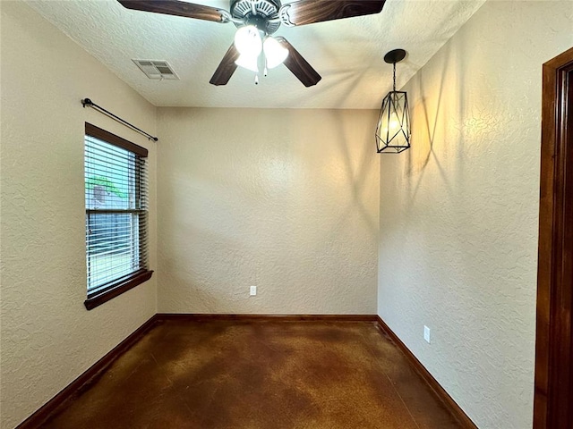 empty room with a ceiling fan, visible vents, a textured wall, and baseboards