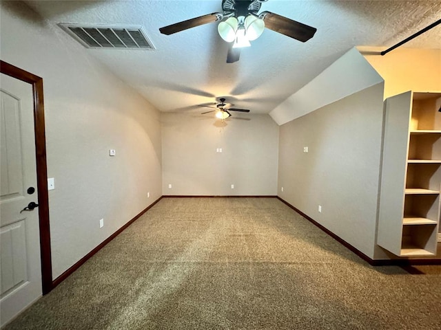 unfurnished room with a textured ceiling, visible vents, ceiling fan, baseboards, and light carpet