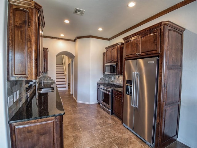 1416 Glenolde Pl, Edmond, OK 73003 - kitchen featuring high end appliances, arched walkways, dark brown cabinets, a sink, and baseboards