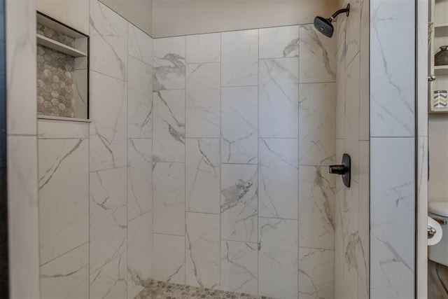 full bath featuring toilet and a tile shower