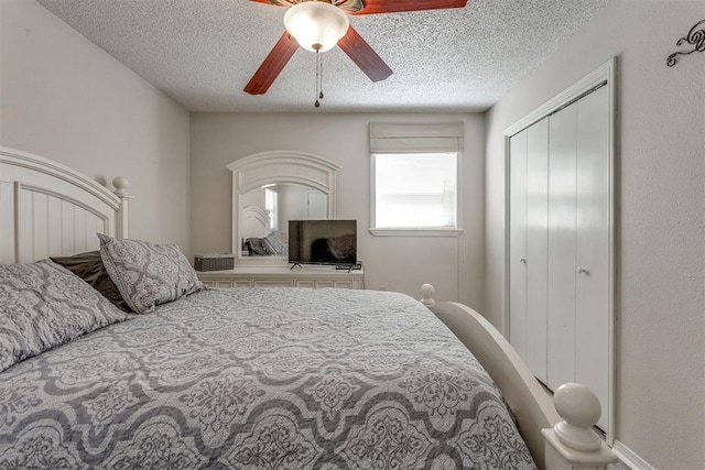 bedroom featuring a ceiling fan, baseboards, a textured ceiling, and a closet