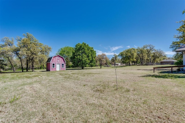 view of yard with fence, an outdoor structure, and a barn