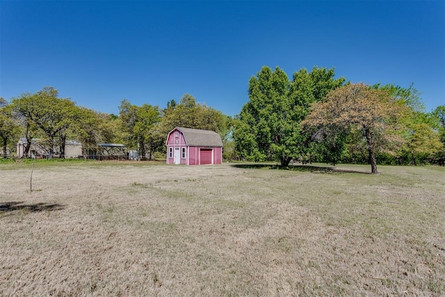 view of yard with an outdoor structure, a barn, and a garage