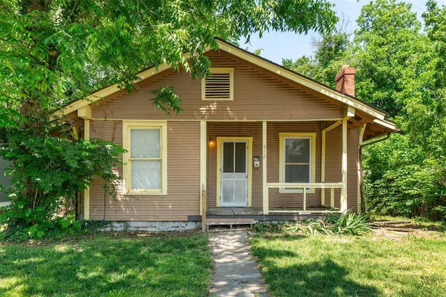 912 Classen Blvd, Norman, OK 73071 - bungalow-style house with covered porch, a chimney, and a front yard