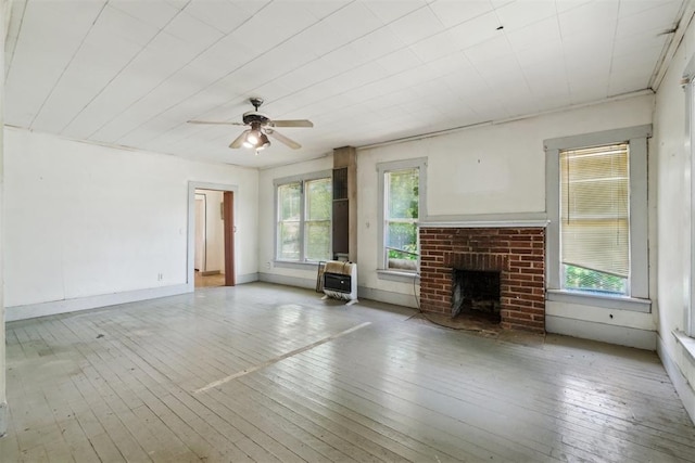 912 Classen Blvd, Norman, OK 73071 - unfurnished living room featuring wood-type flooring, a brick fireplace, a ceiling fan, and heating unit