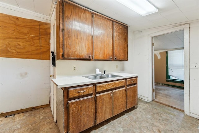 912 Classen Blvd, Norman, OK 73071 - kitchen featuring a sink, light countertops, and brown cabinetry