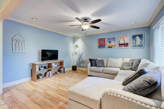 living area featuring wood finished floors, a ceiling fan, crown molding, and baseboards