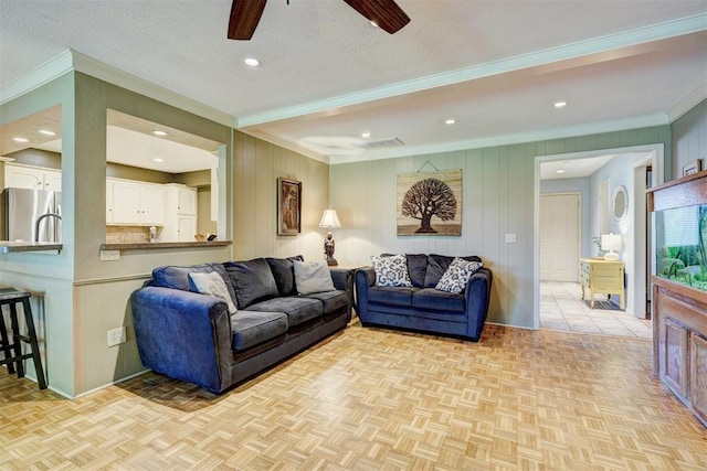 living area featuring ornamental molding, recessed lighting, ceiling fan, and visible vents