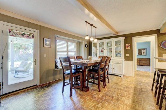 dining space with ornamental molding and beamed ceiling