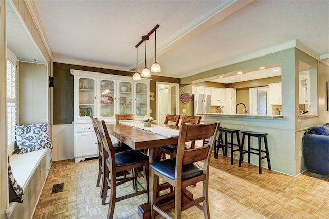 dining room featuring ornamental molding, a wainscoted wall, and visible vents