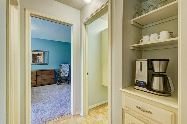 corridor with baseboards and a textured ceiling