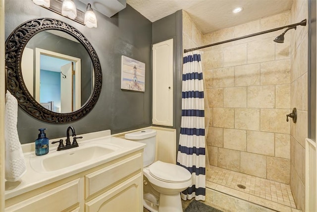bathroom featuring a tile shower, toilet, and vanity