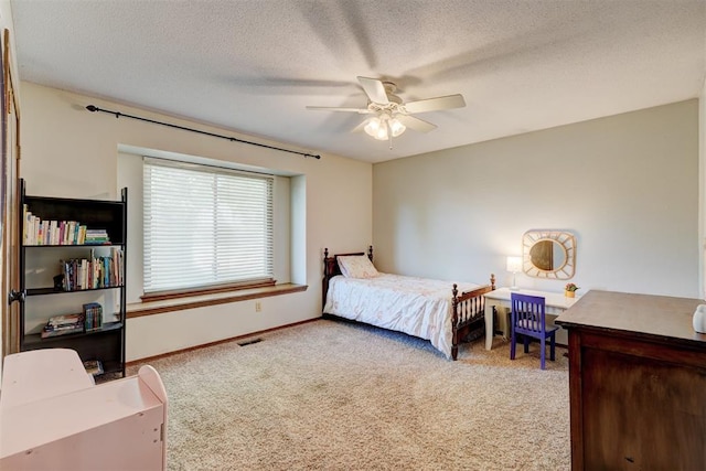 bedroom with carpet, baseboards, visible vents, a ceiling fan, and a textured ceiling