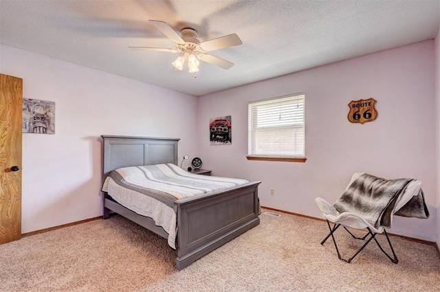 bedroom with a ceiling fan, visible vents, light colored carpet, and baseboards